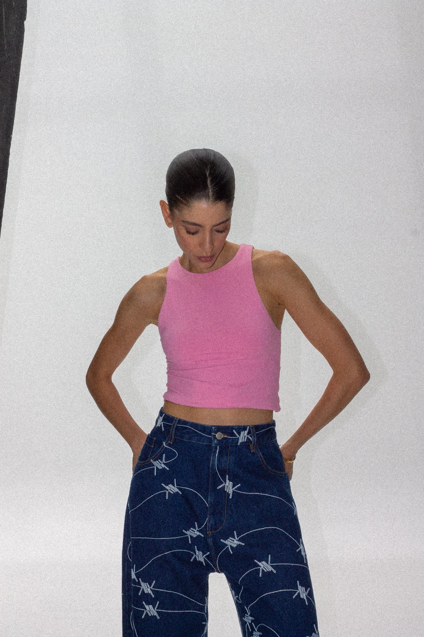 Model in a pink top and barbed-wire print jeans