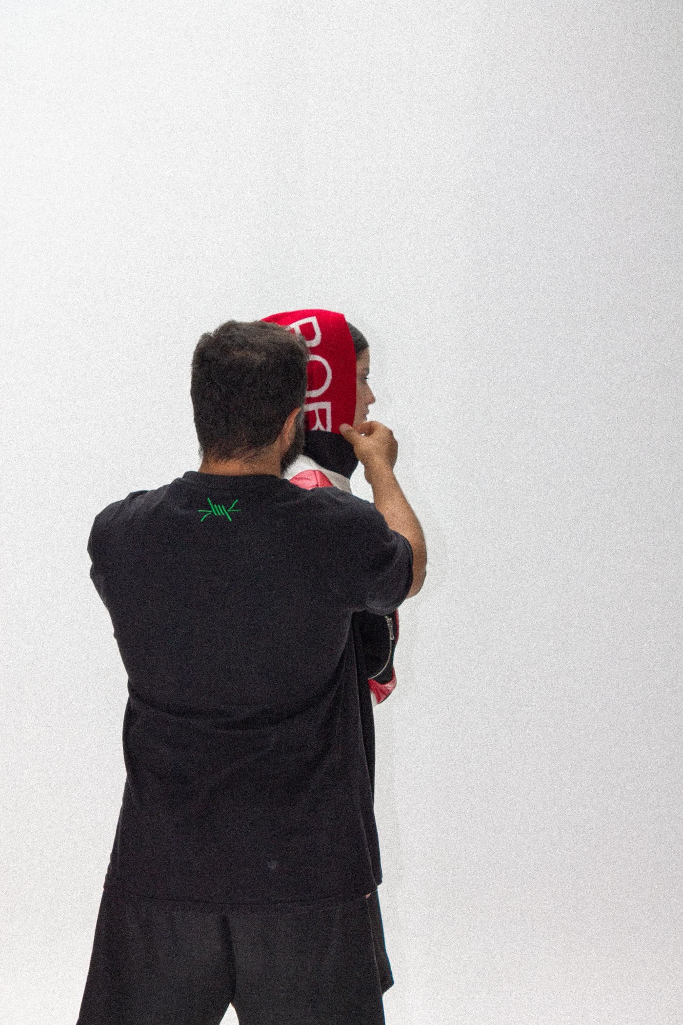 Stylist adjusting a red hood on a model