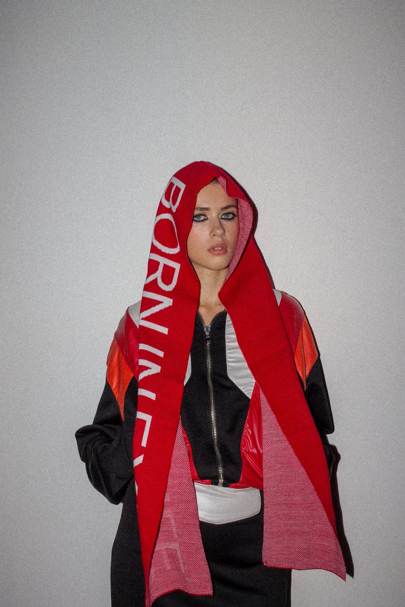 Model in a red Born in Exile scarf worn as a hood