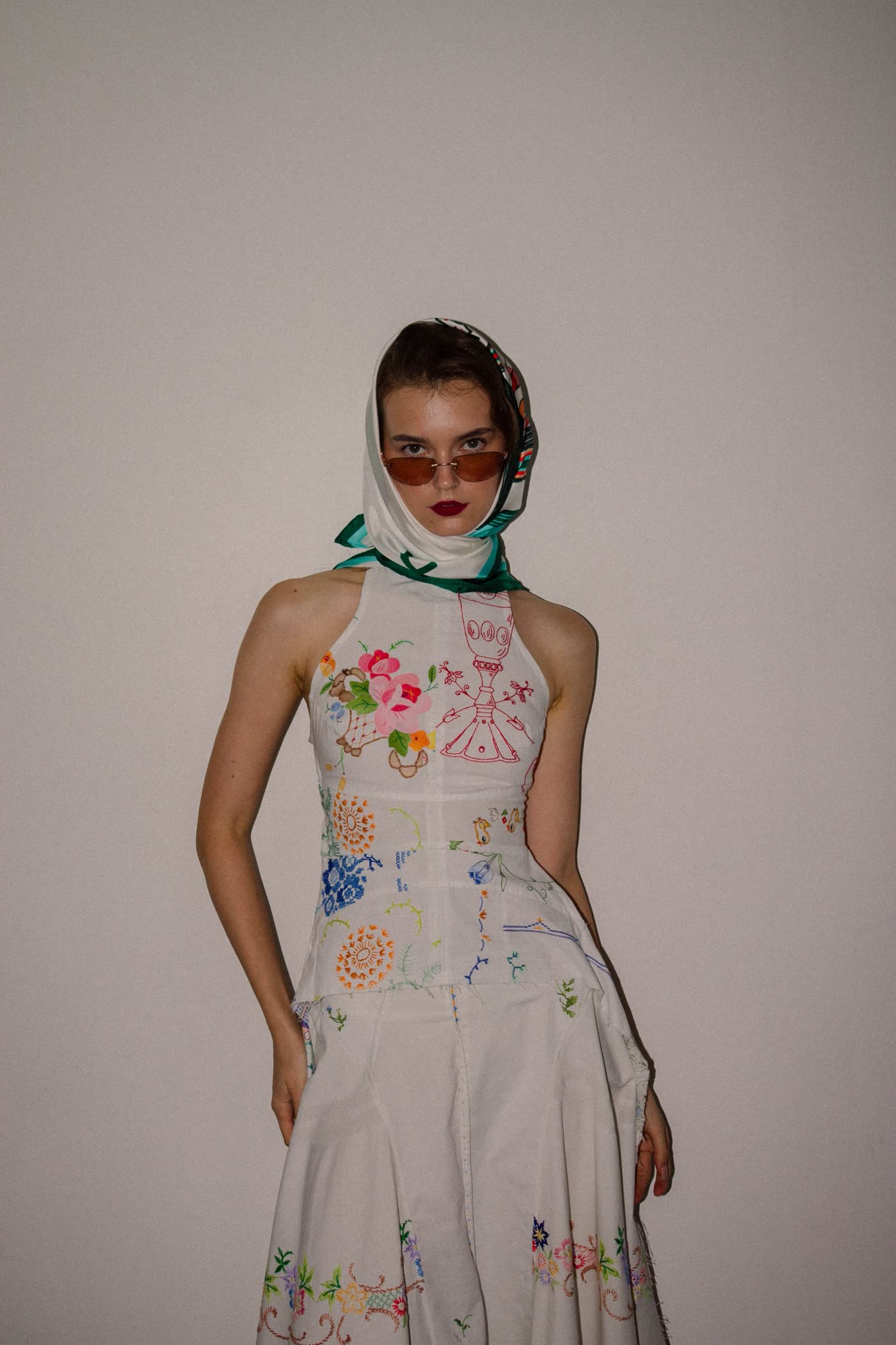 Model in an embroidered dress with a silk headscarf