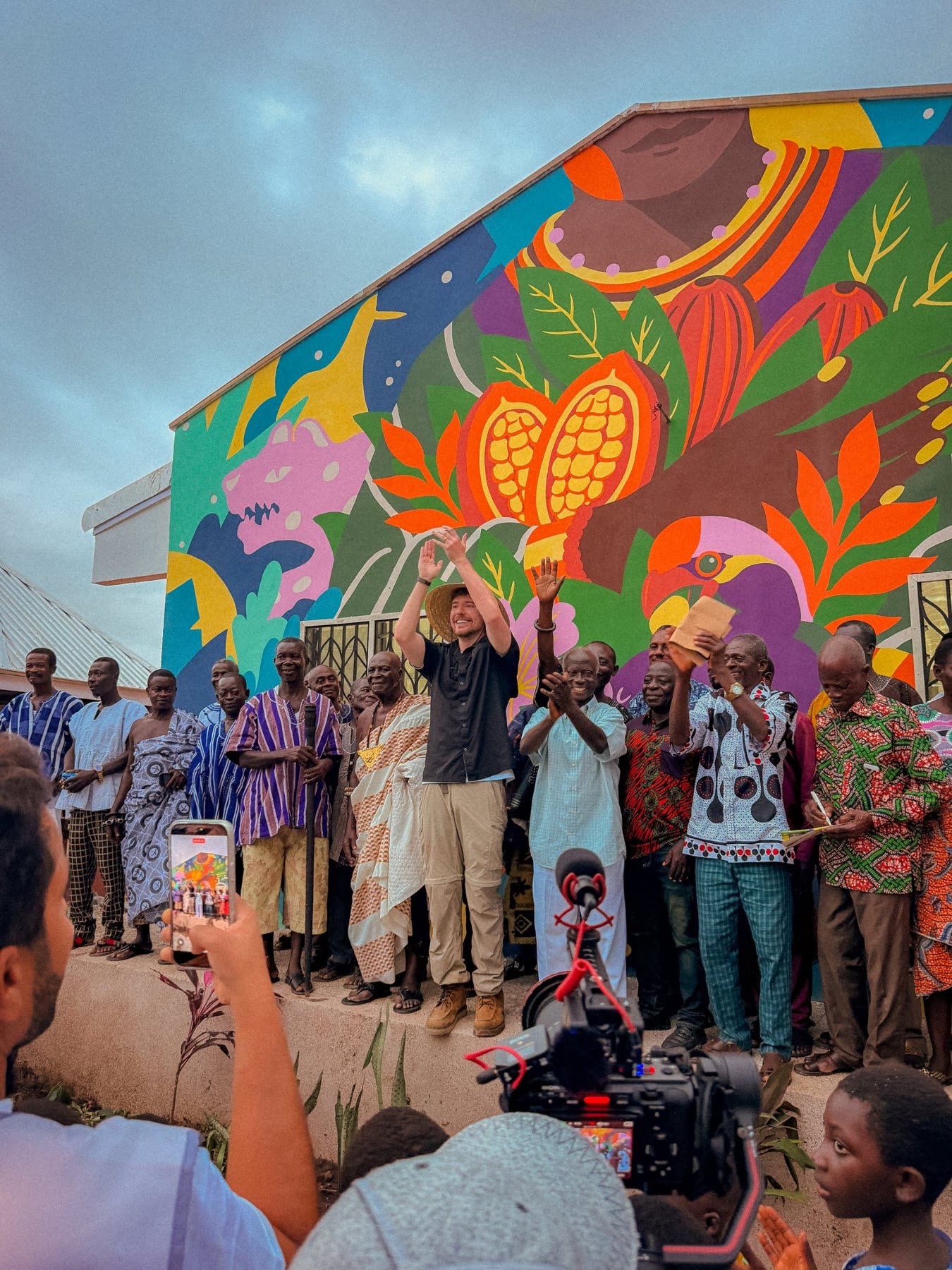 Crowd in front of a colourful mural in Ghana