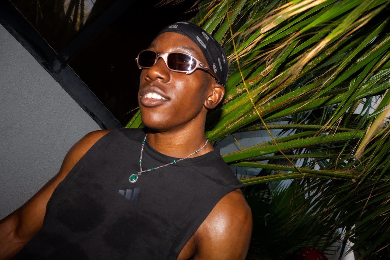 Man in sunglasses among palm leaves