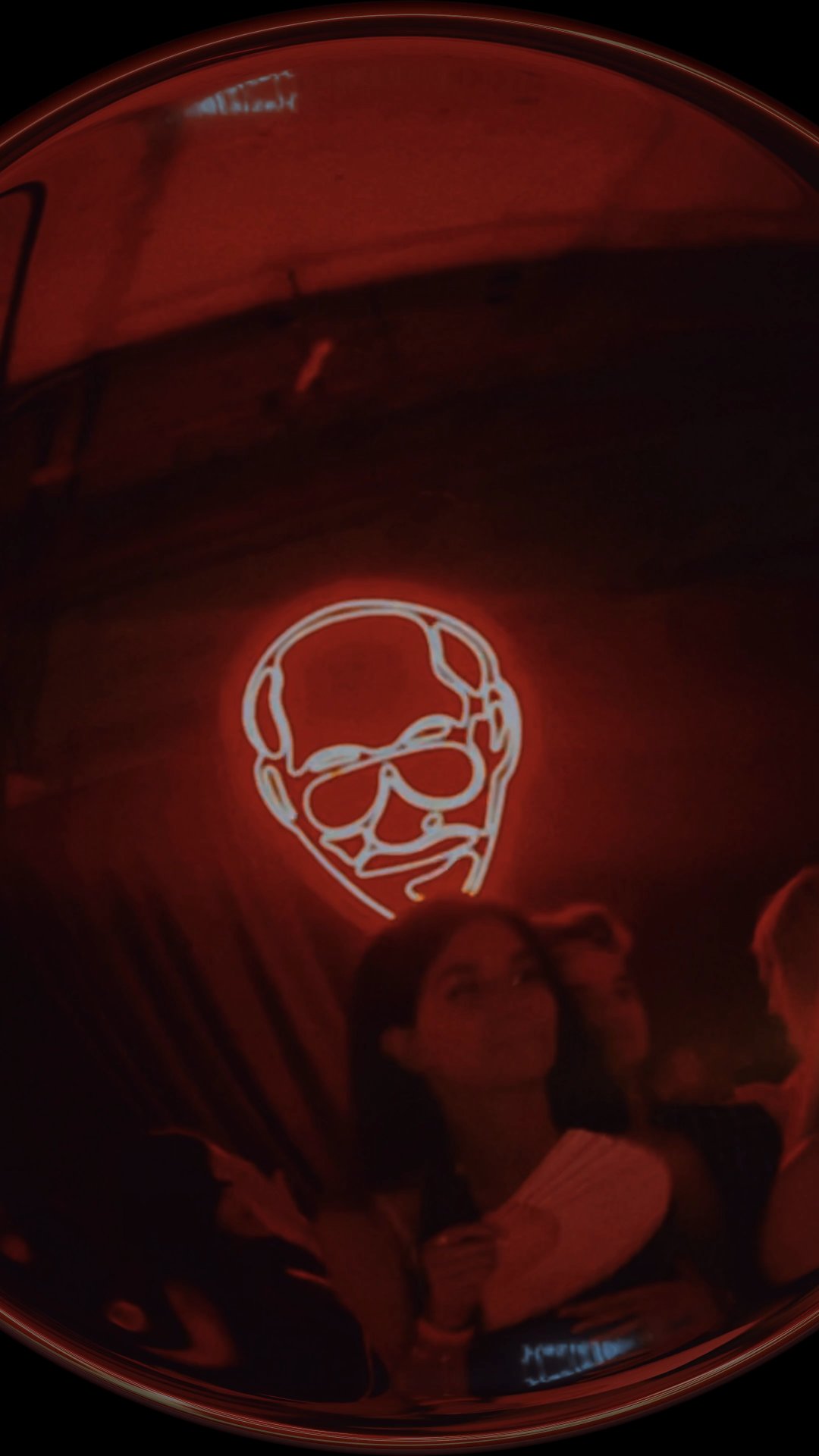 Fisheye shot of a neon skull over a crowd