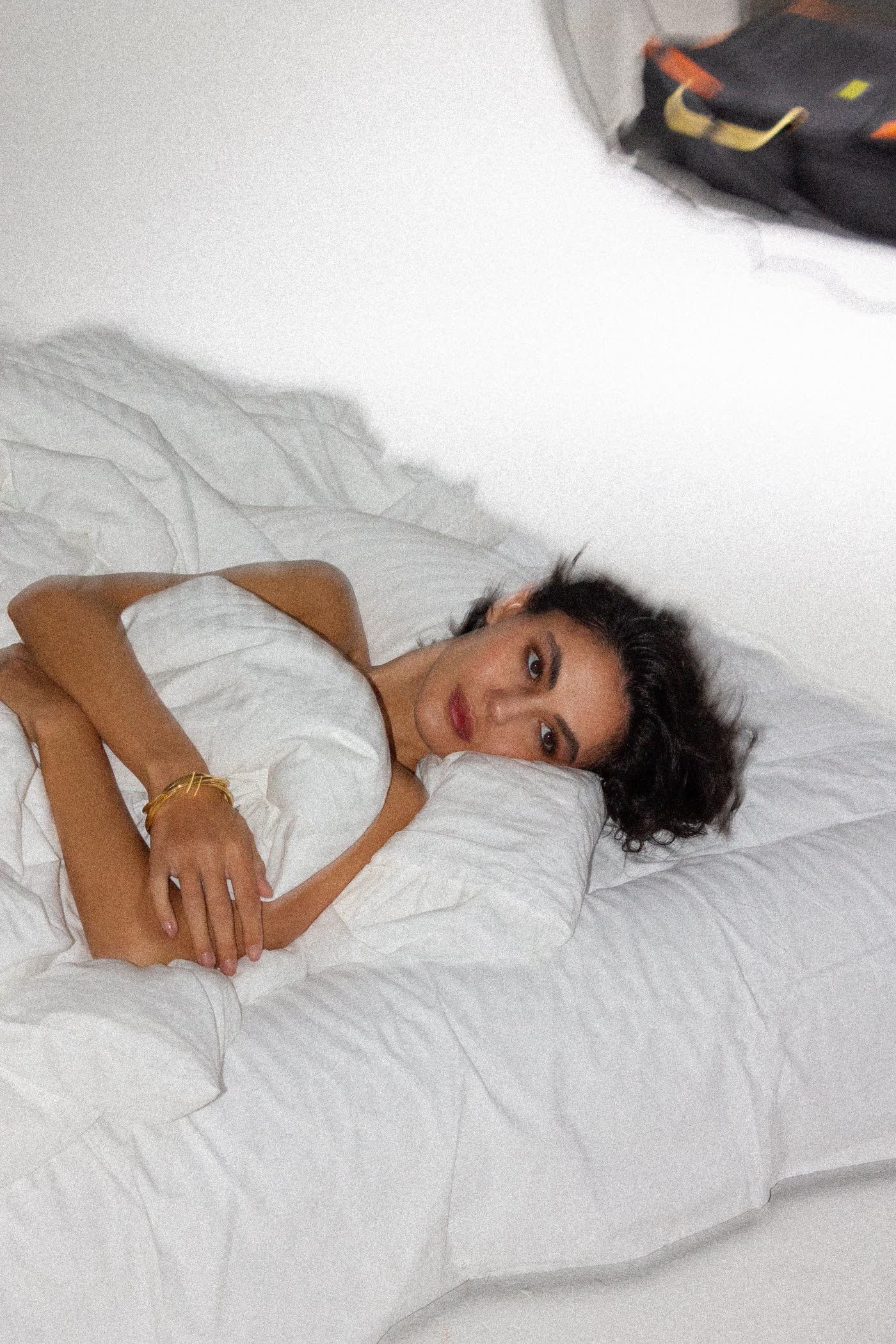 Model wrapped in white sheets, shot from above