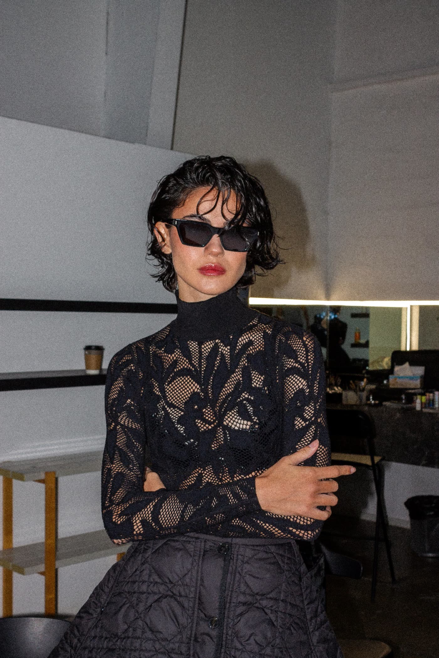 Model in black lace and sunglasses with arms crossed