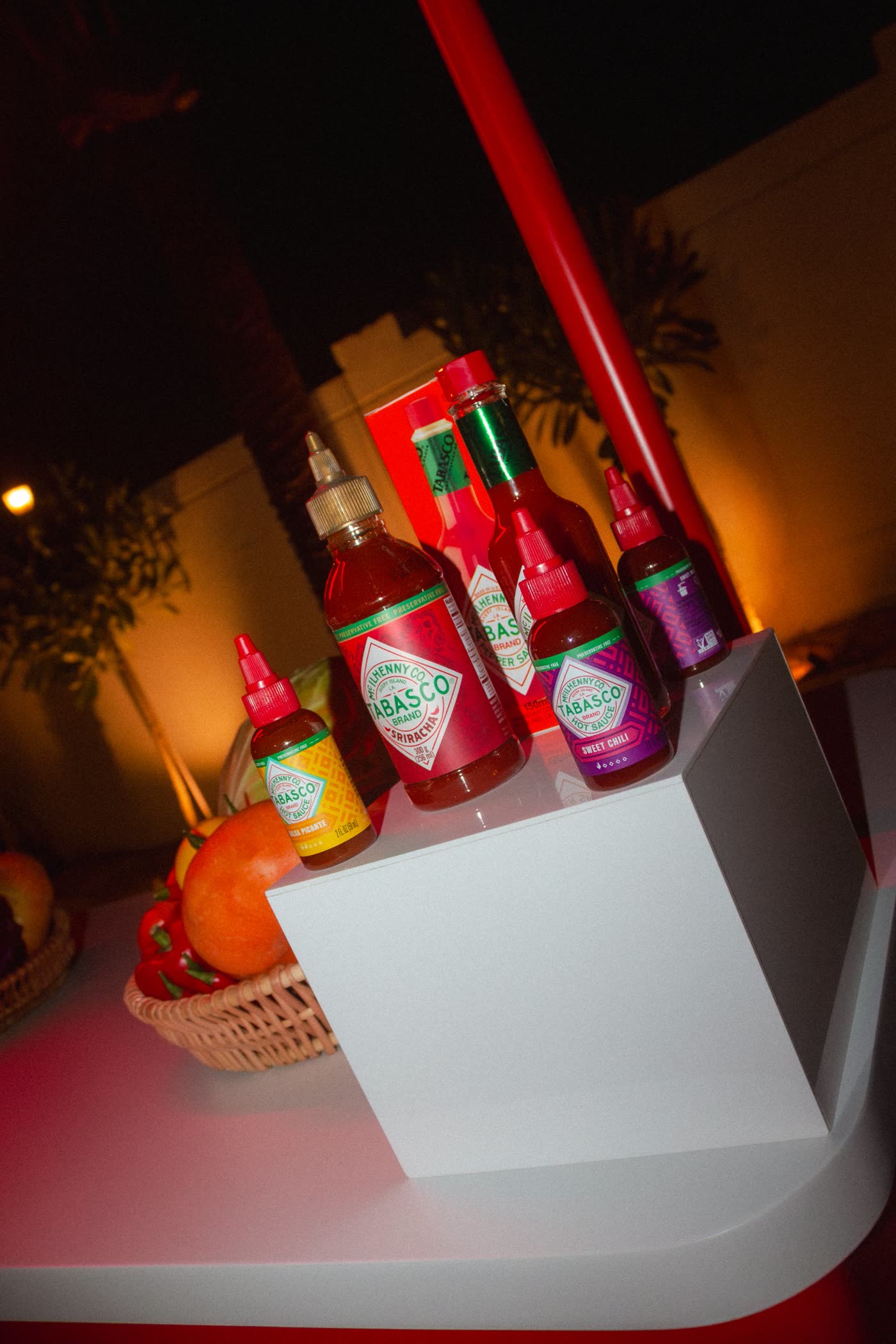 Tabasco Sriracha, Sweet Chili, Salsa Picante and Pepper Sauce bottles on a white plinth